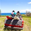 Features - Off road vehicle driving toward beach with two women in back