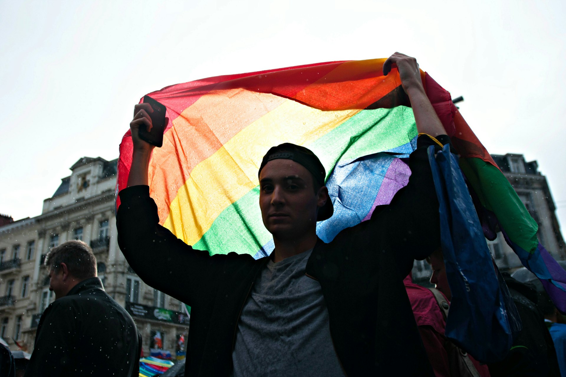 A man holds a rainbow flag aloft in Brussels city centre 