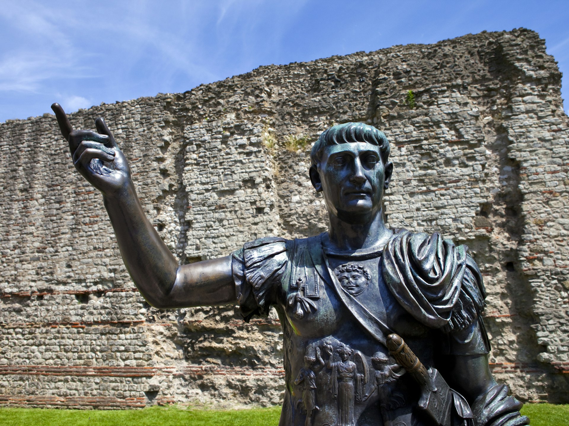 A statue of Roman Emperor Trajan in front of the London Wall