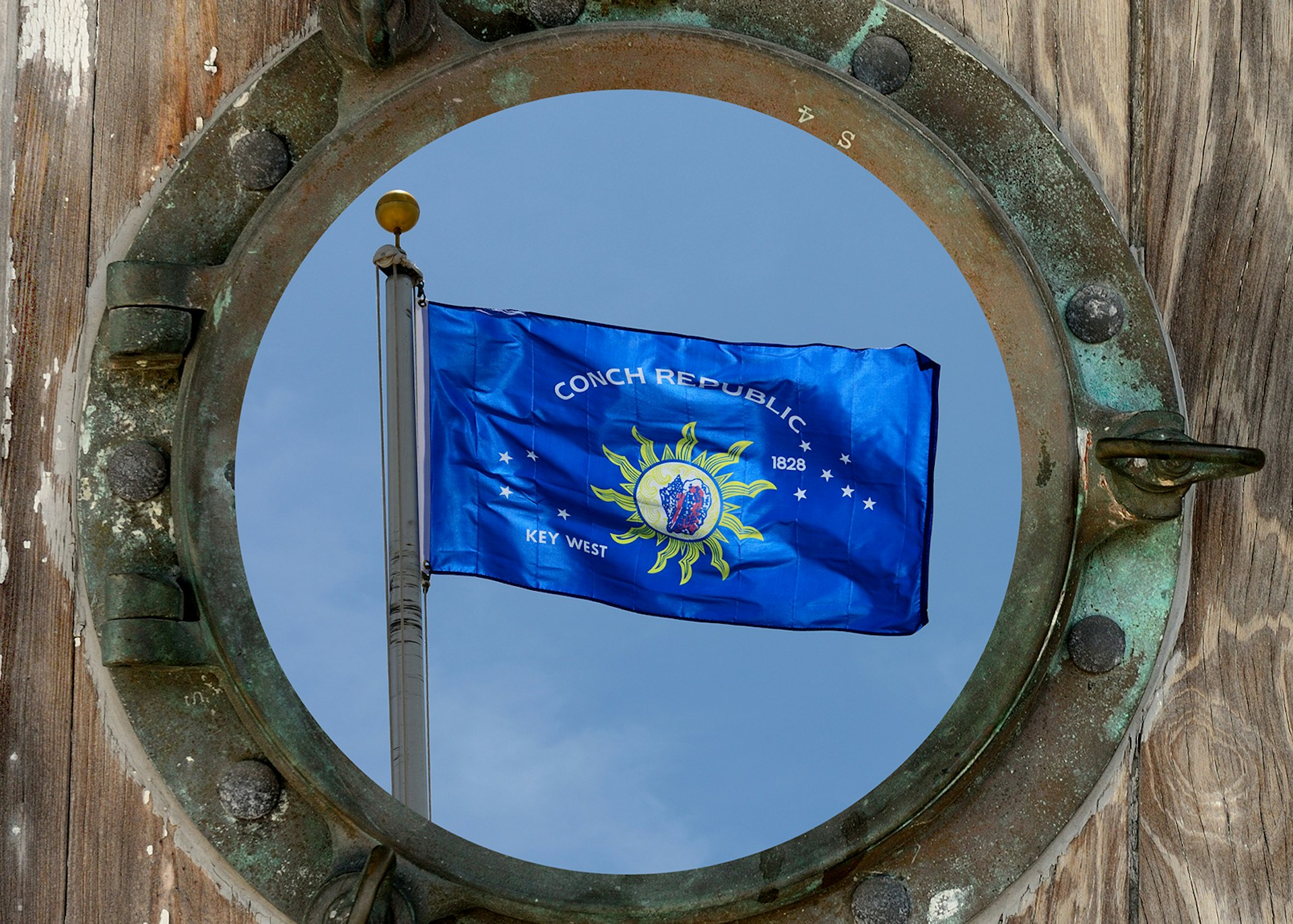 The flag of the Conch Republic seen through an old ship's porthole © Chuck Wagner / Shutterstock