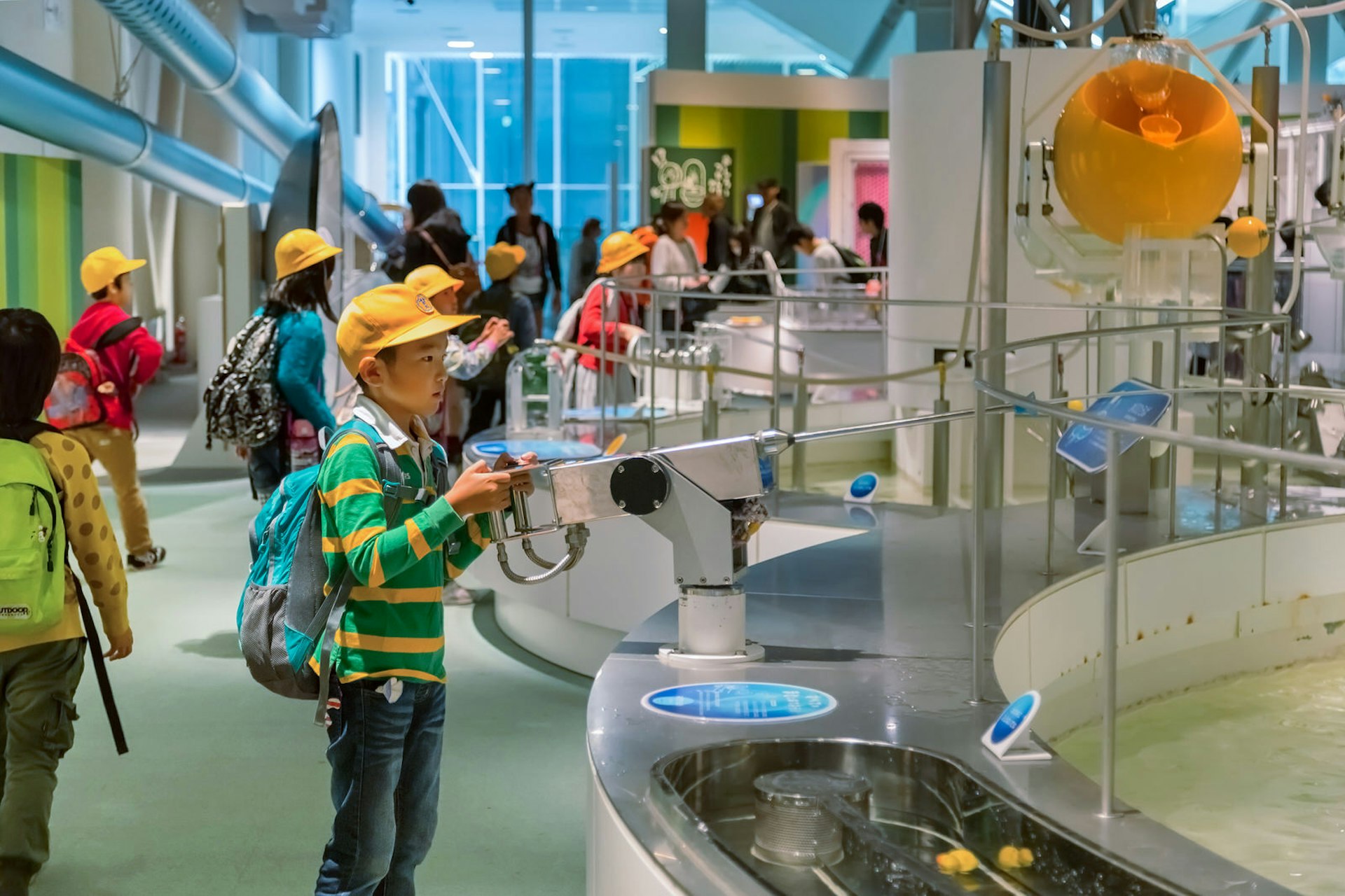 A school-age child plays with a hands-on exhibit, shooting water into a pool at the museum