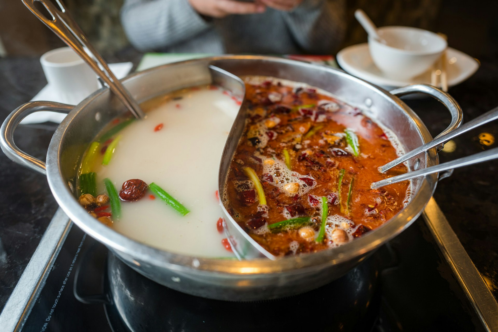 The split 'yuanyang' hotpot allows sampling of both spicy and mild broths © Yiming Chen / Getty