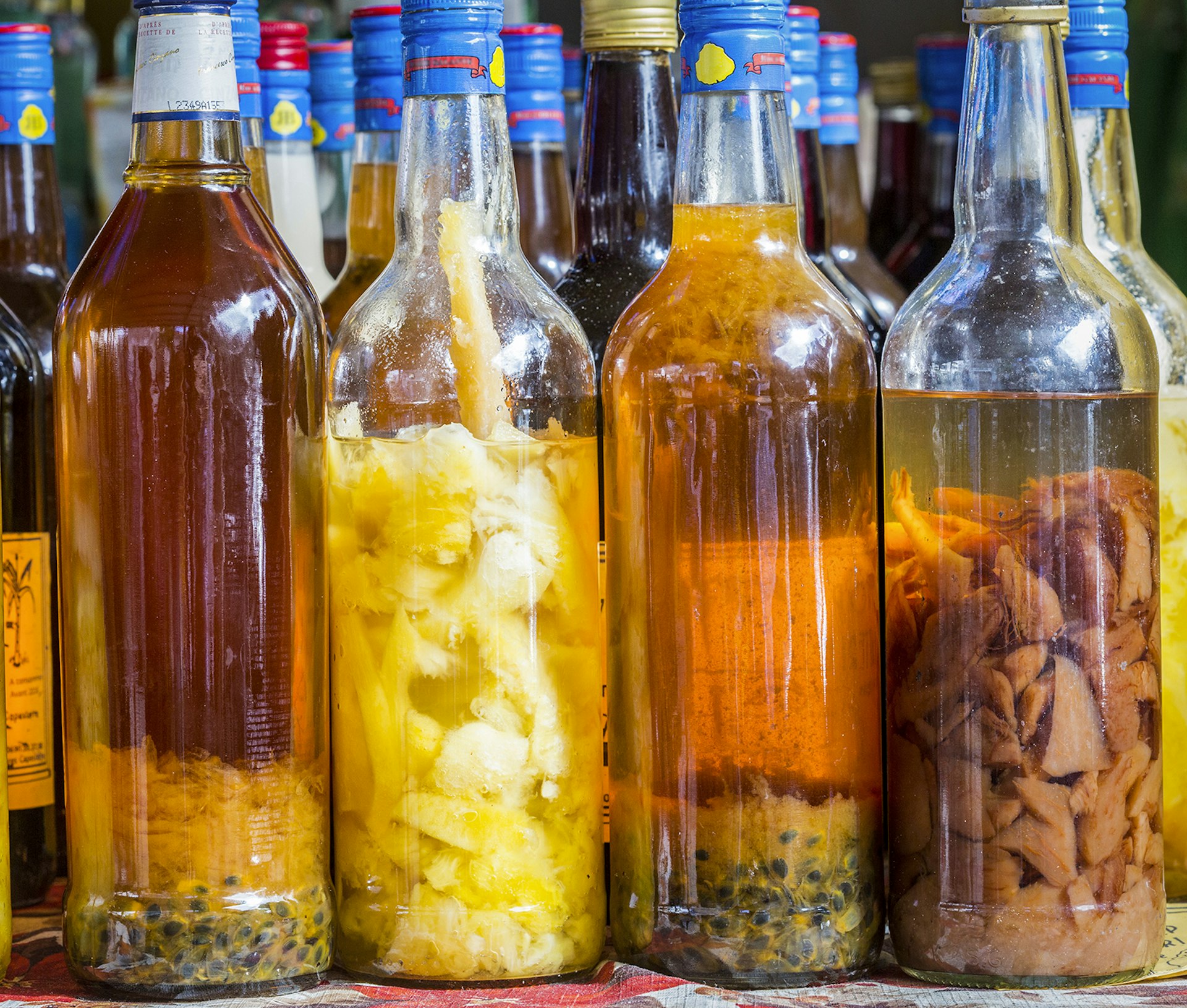 Features - France, Guadeloupe (French West Indies), Marie Galante, Grand Bourg, market stall with local rums arranged (pineapple, passion fruit)