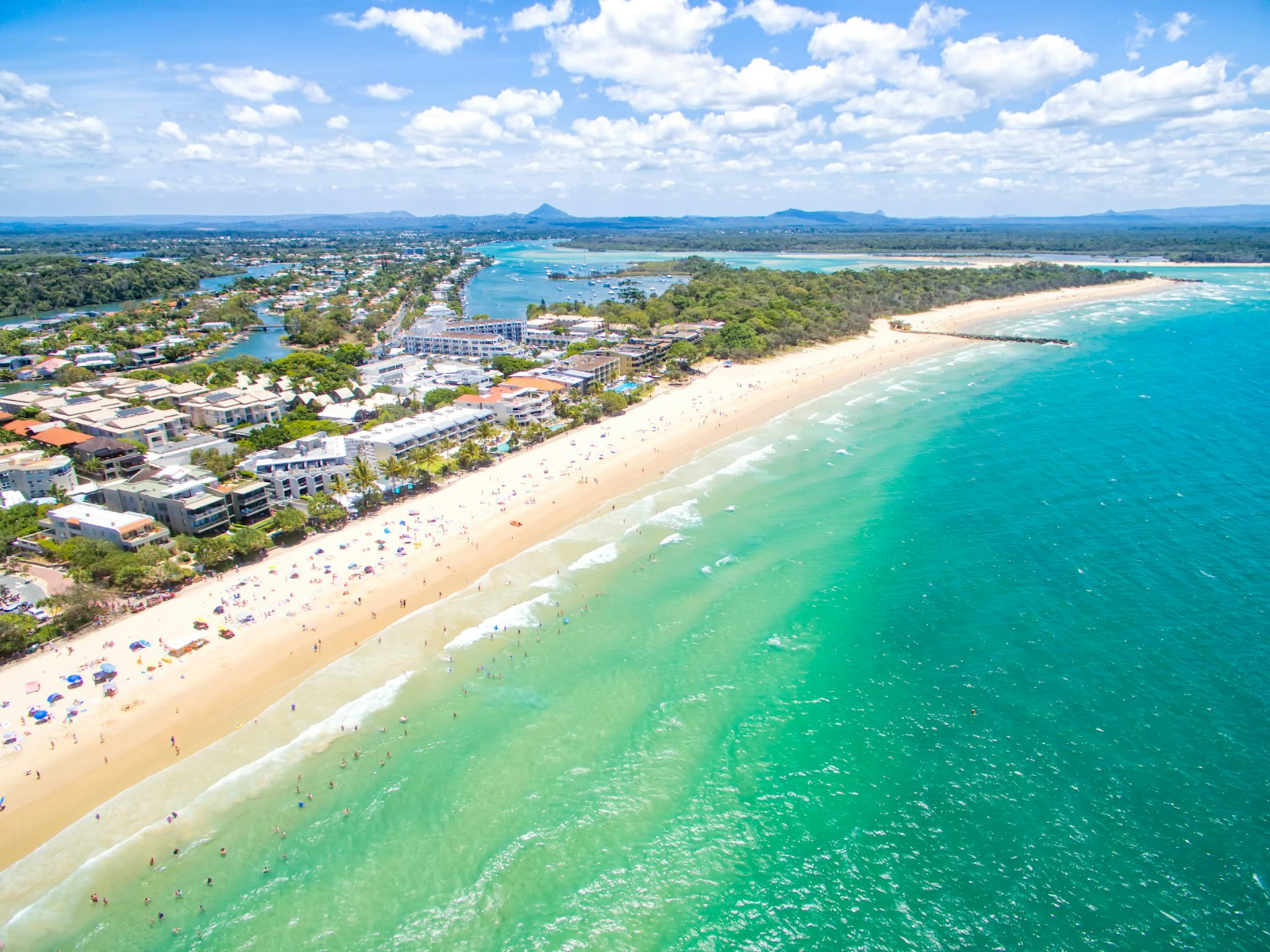 An aerial view of Noosa beach with views over the waterfront buildings behind