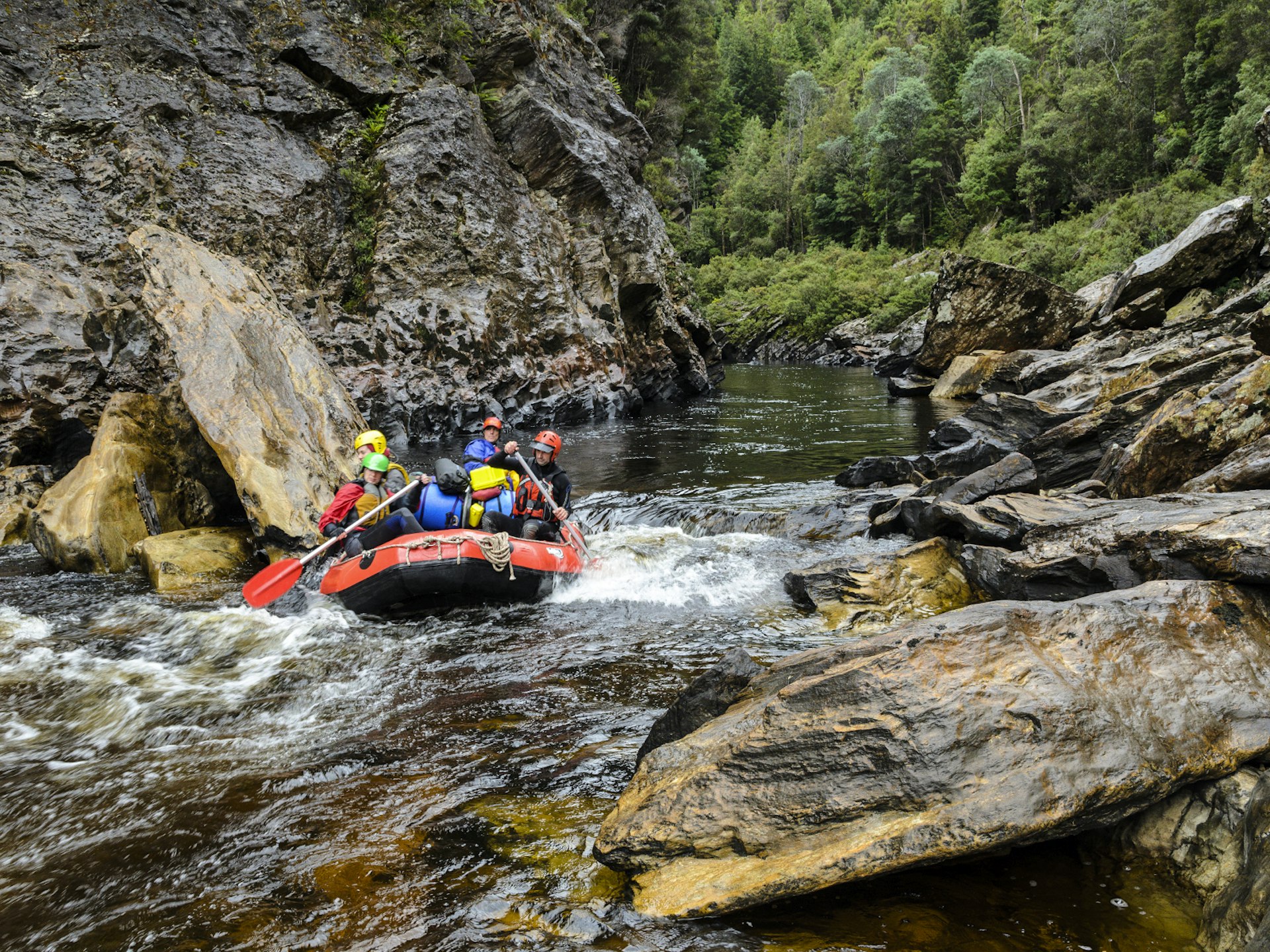 A group of people raft down choppy waters of the Franklin River, Tasmania