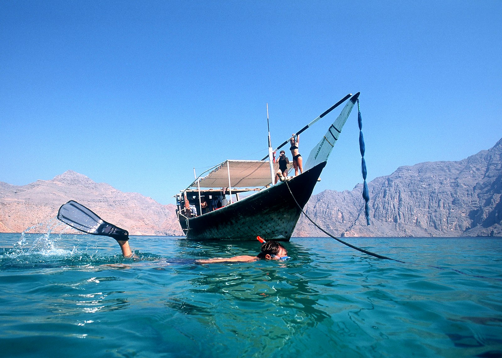 Tourists swimming in the jade waters of the Musandam Peninsula, Oman © Jochen Tack / Getty Images