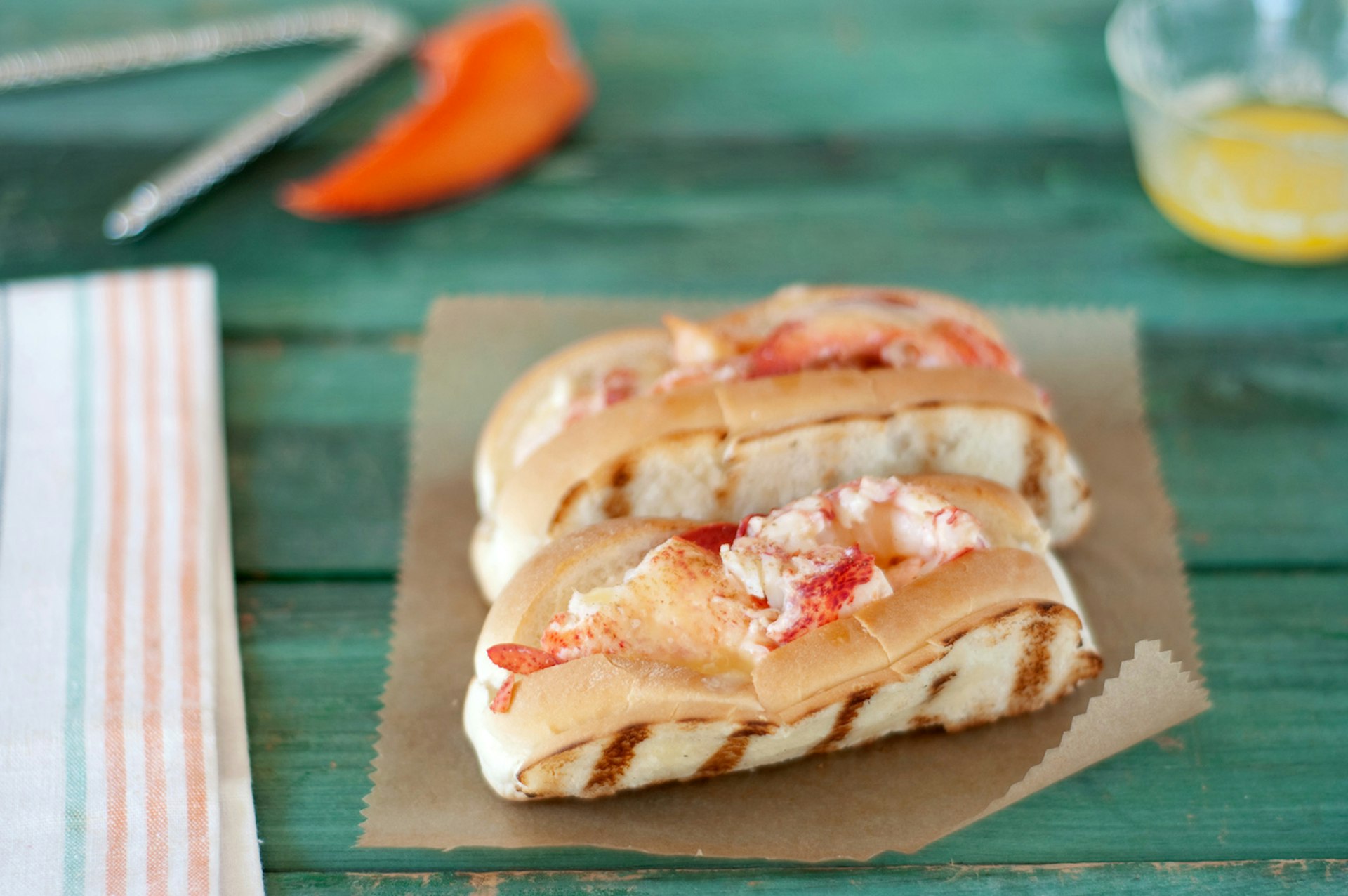 two lobster rolls on brown paper in Maine