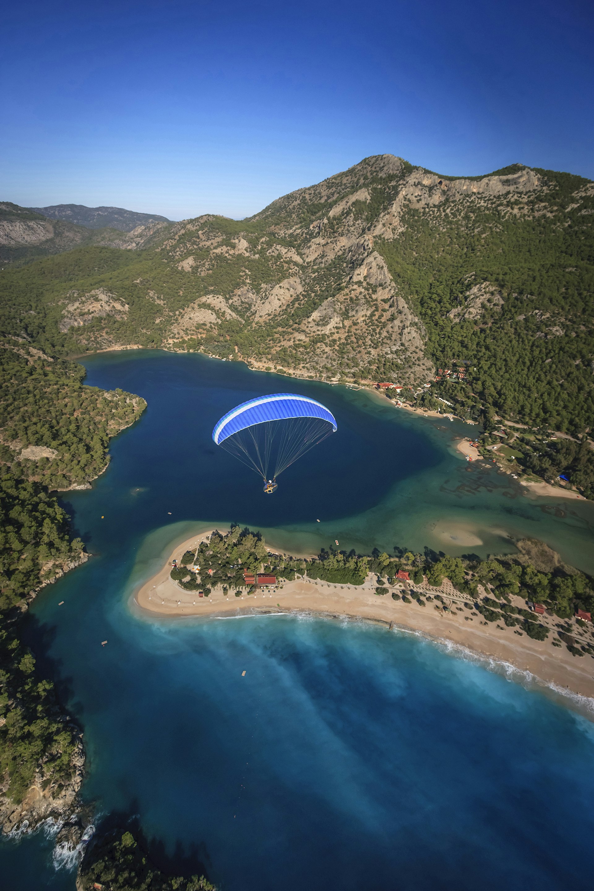 A paraglider flying over Turkey's Ölüdeniz Beach ©  Danita Delimont / Getty Images