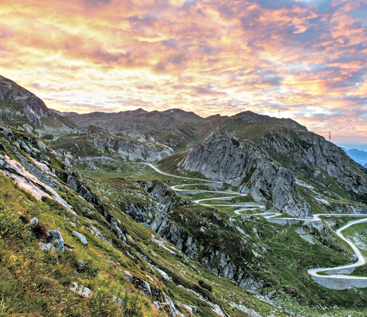 Switzerland's famed hairpin turns twist and turn up a mountain at sunset