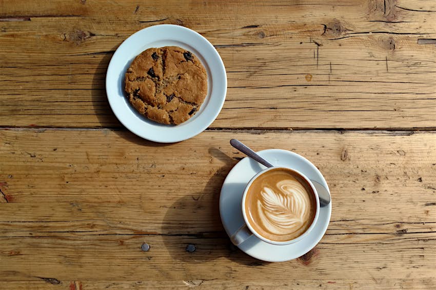Berlin's best vegan - a cookie and coffee on a wooden table at Two Planets in Neukölln, Berlin