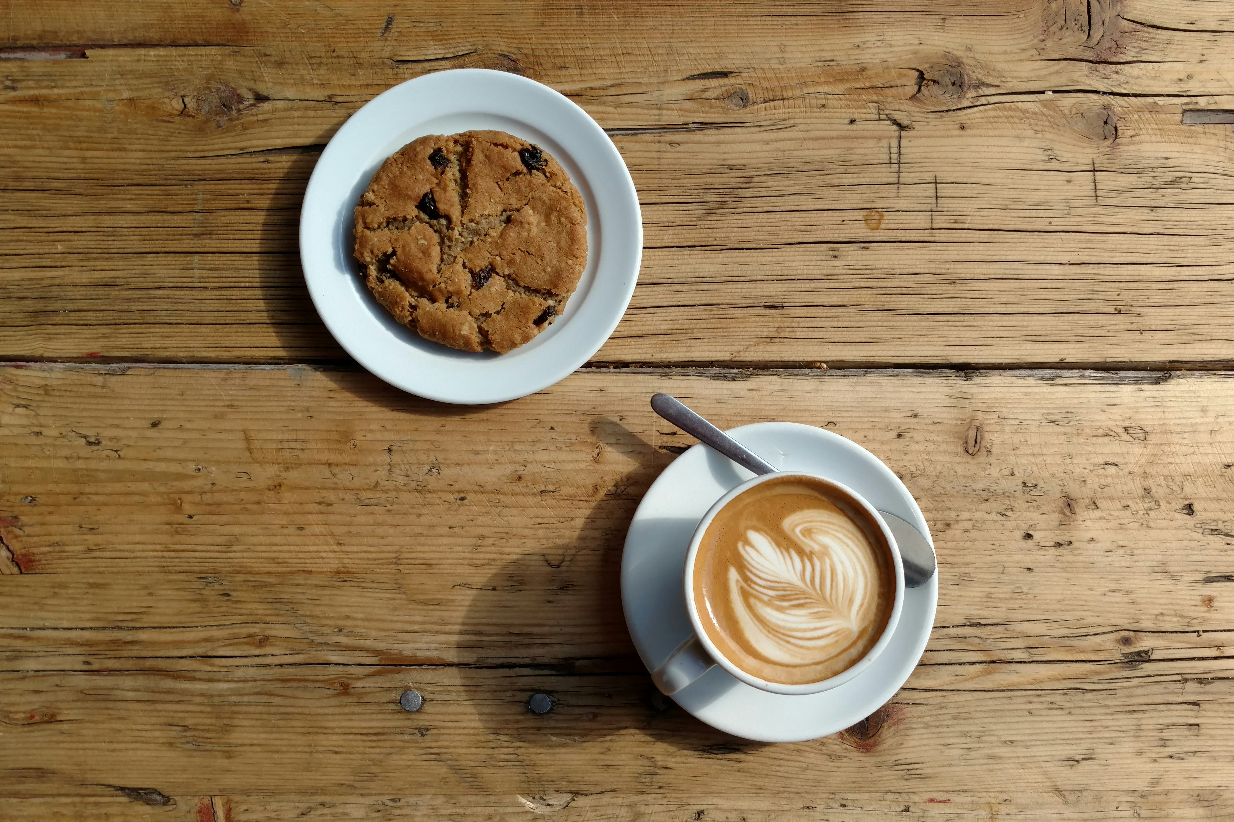 Berlin's best vegan - a cookie and coffee on a wooden table at Two Planets in Neukölln, Berlin