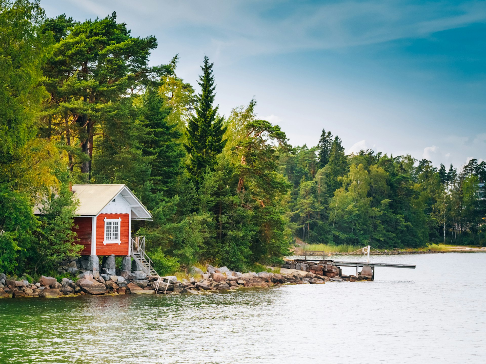 A Finnish sauna nestled amongst a forest on the edge of a lake