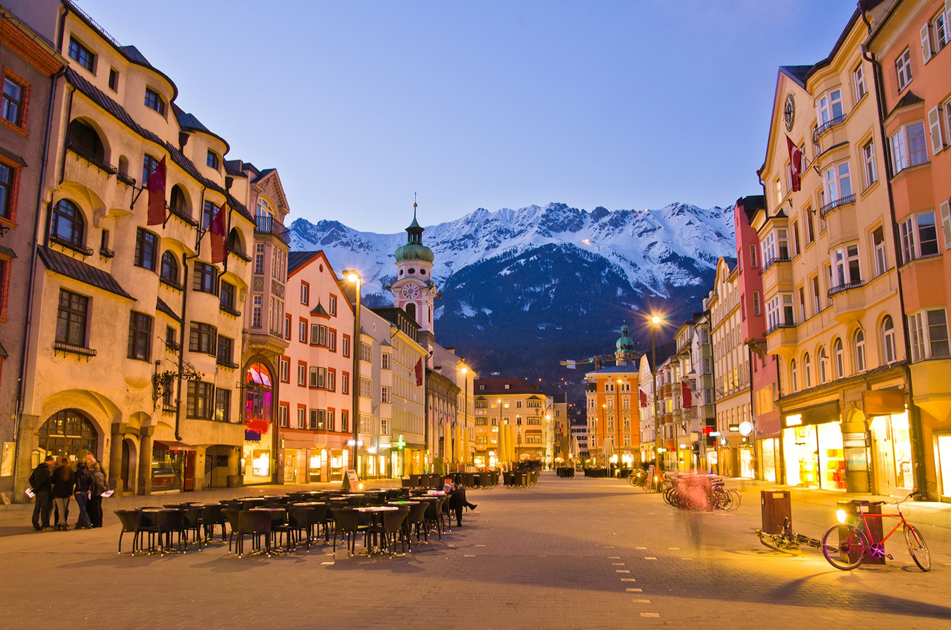 A city street with snow-covered mountains looming in the background, Innsbruck, Austria