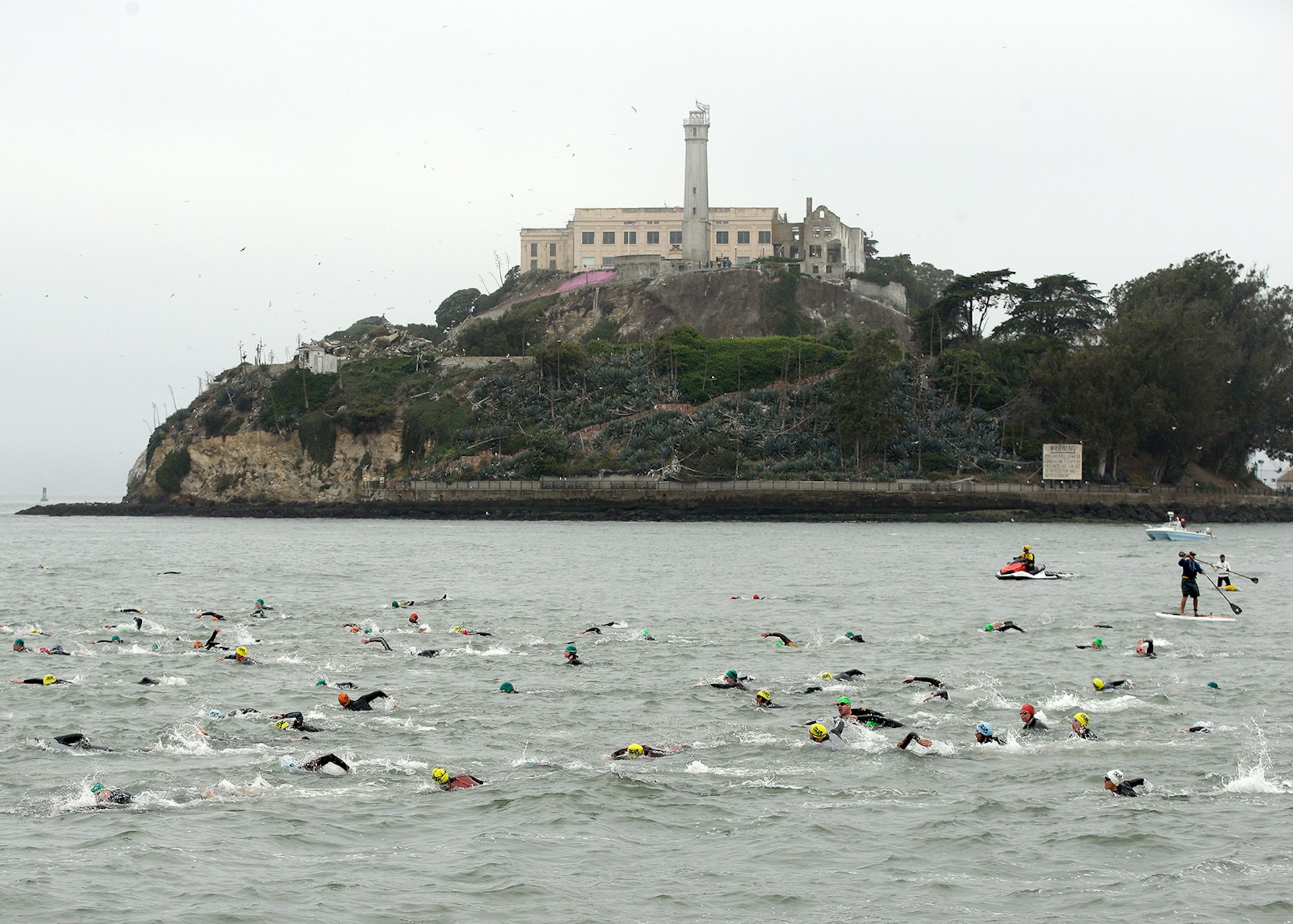 Triathletes swimming past Alcatraz in the chilly water of San Francisco Bay © Ezra Shaw / Getty Images