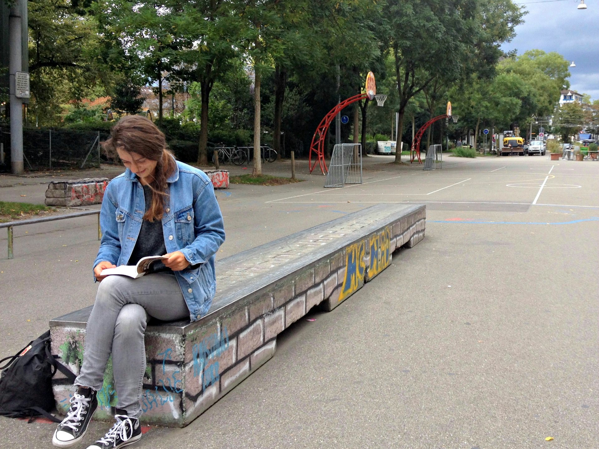 Woman reading at the Bäckeranlage skate park in Zürich