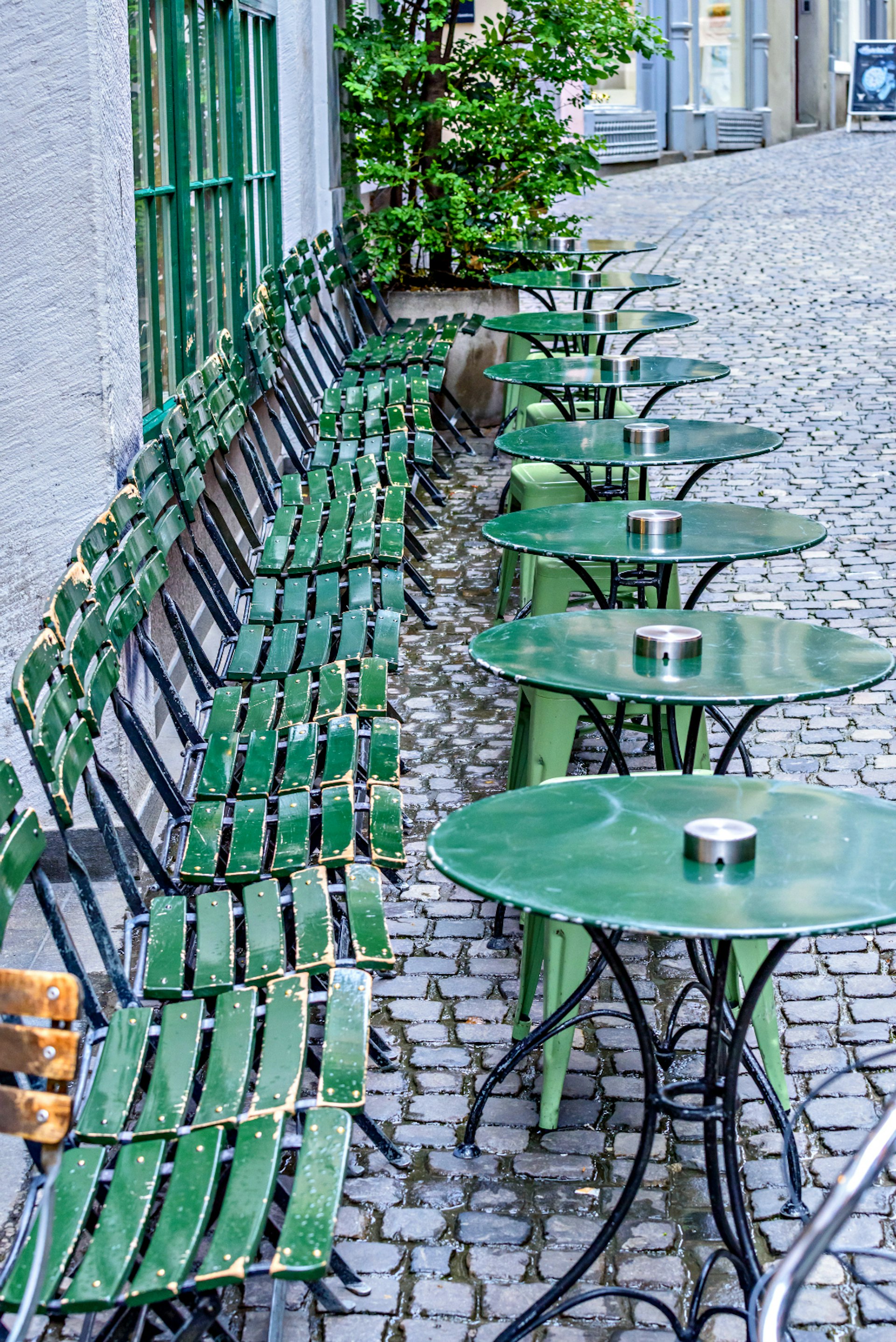 A row of green tables in Zurich city centre
