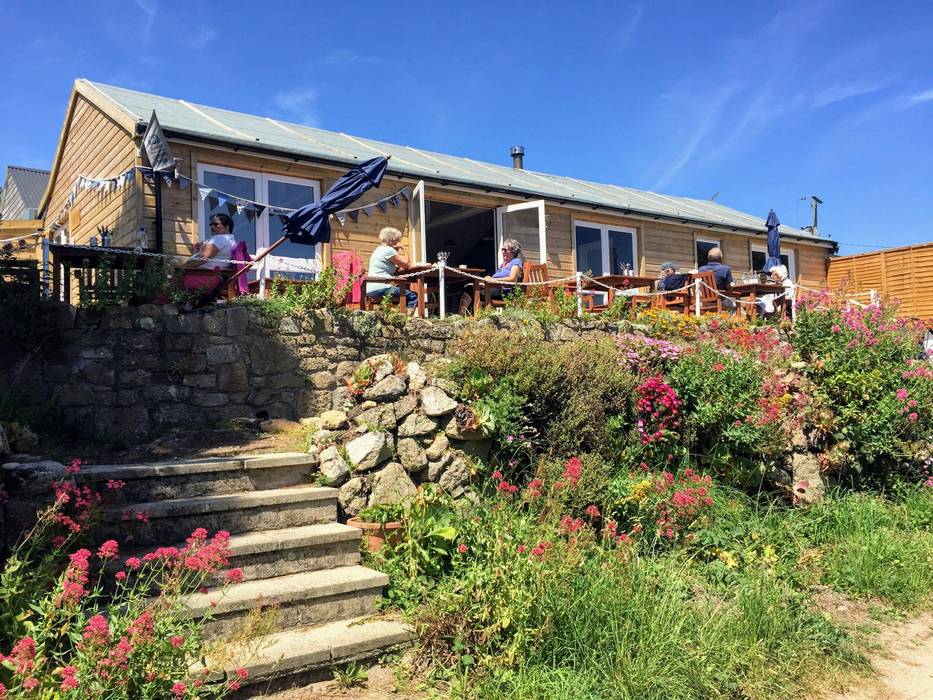 People on the terrace outside Longstone Lodge and Cafe, St Mary's, Isles of Scilly, England, UK © James Kay / Lonely Planet