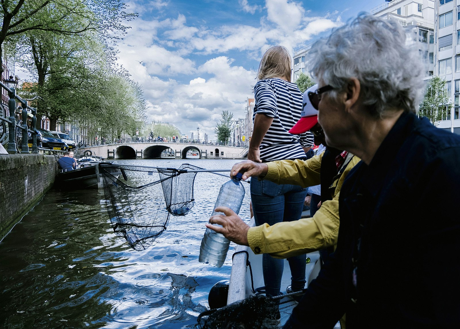 Travellers removing plastic rubbish from a canal in the Netherlands © Plastic Whale