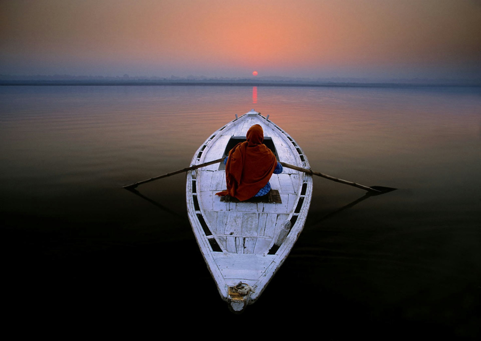 A pilgrim setting out on the Ganges River at dawn © Art Wolfe