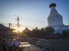View of Miaoying Temple White Dagoba with diners and the sunset.