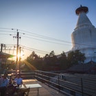 View of Miaoying Temple White Dagoba with diners and the sunset.
