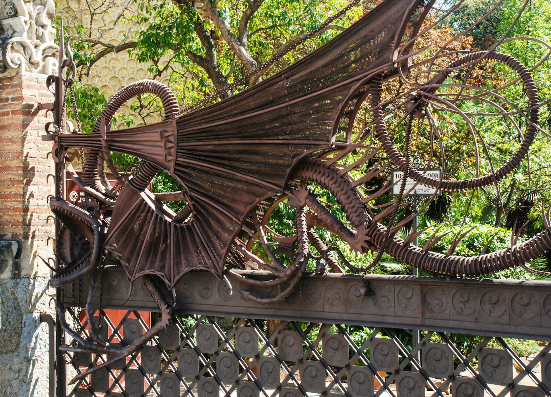 A close-up of Gaudí's intricate, fantastical wrought-iron dragon gate, embellished with likenesses of dragons. 