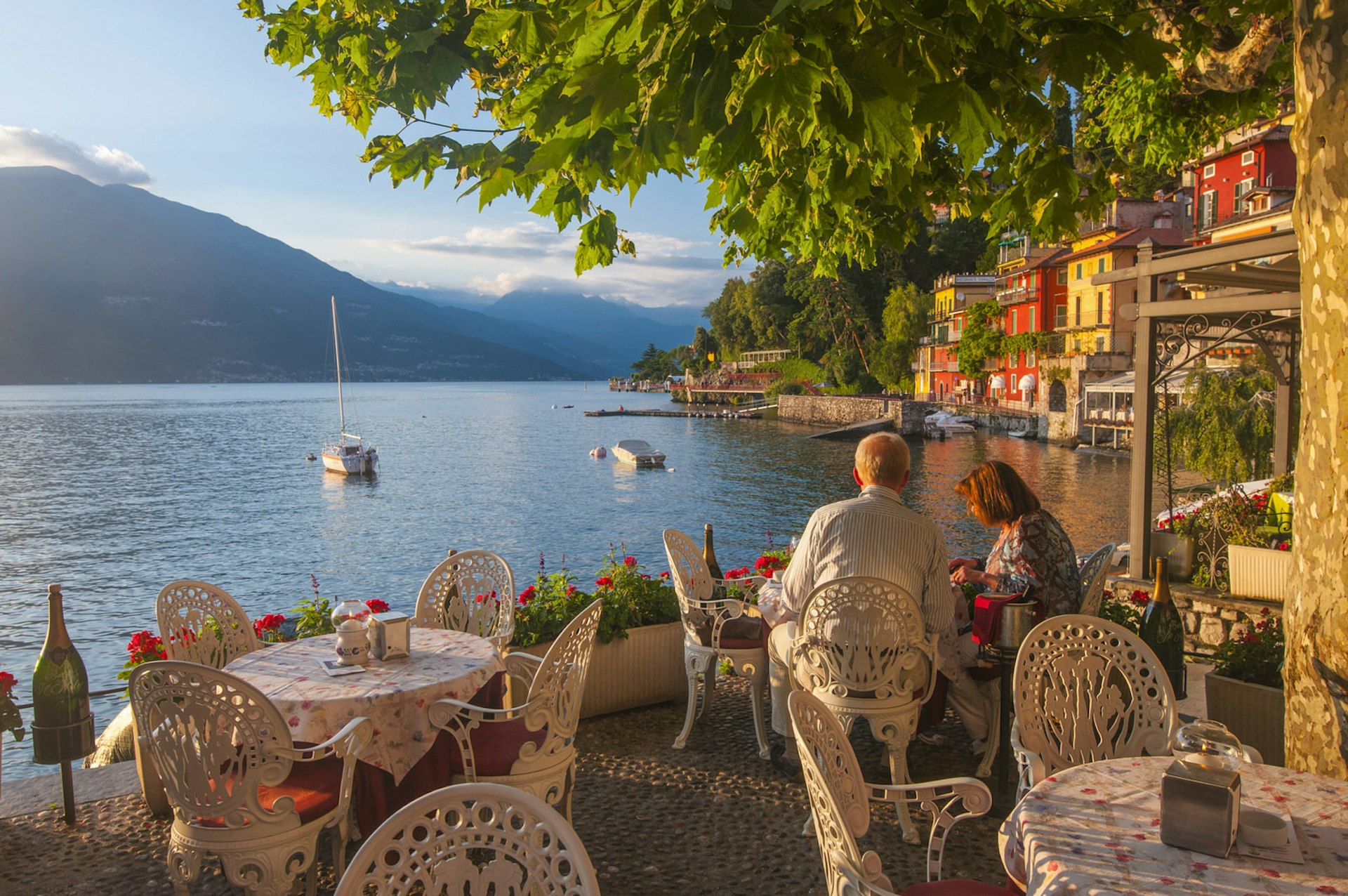 Romantic trip with kids in tow – a couple dine overlooking Lake Como, Italy.