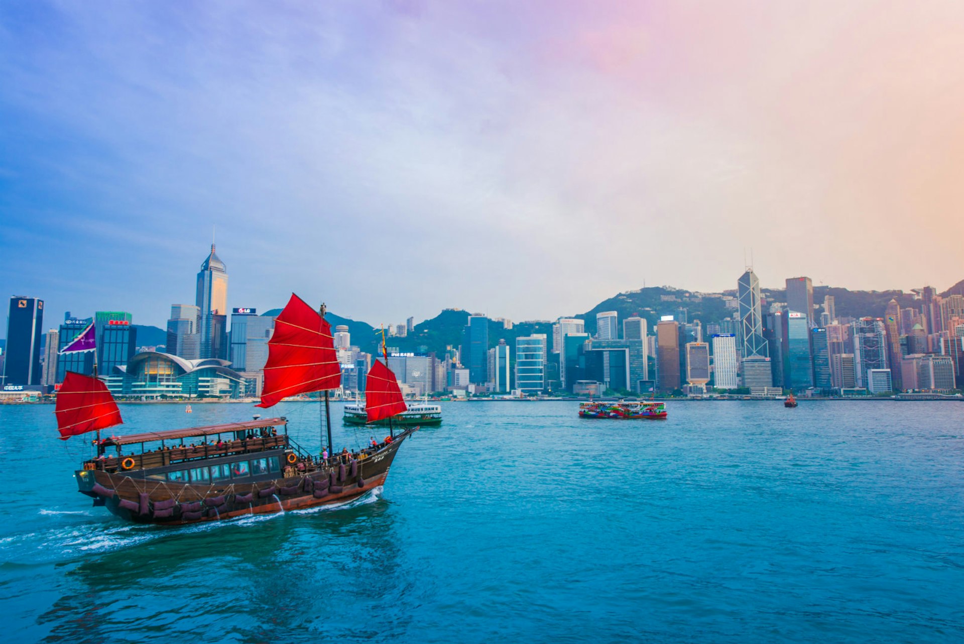 A junk boat sails towards the shores of Hong Kong