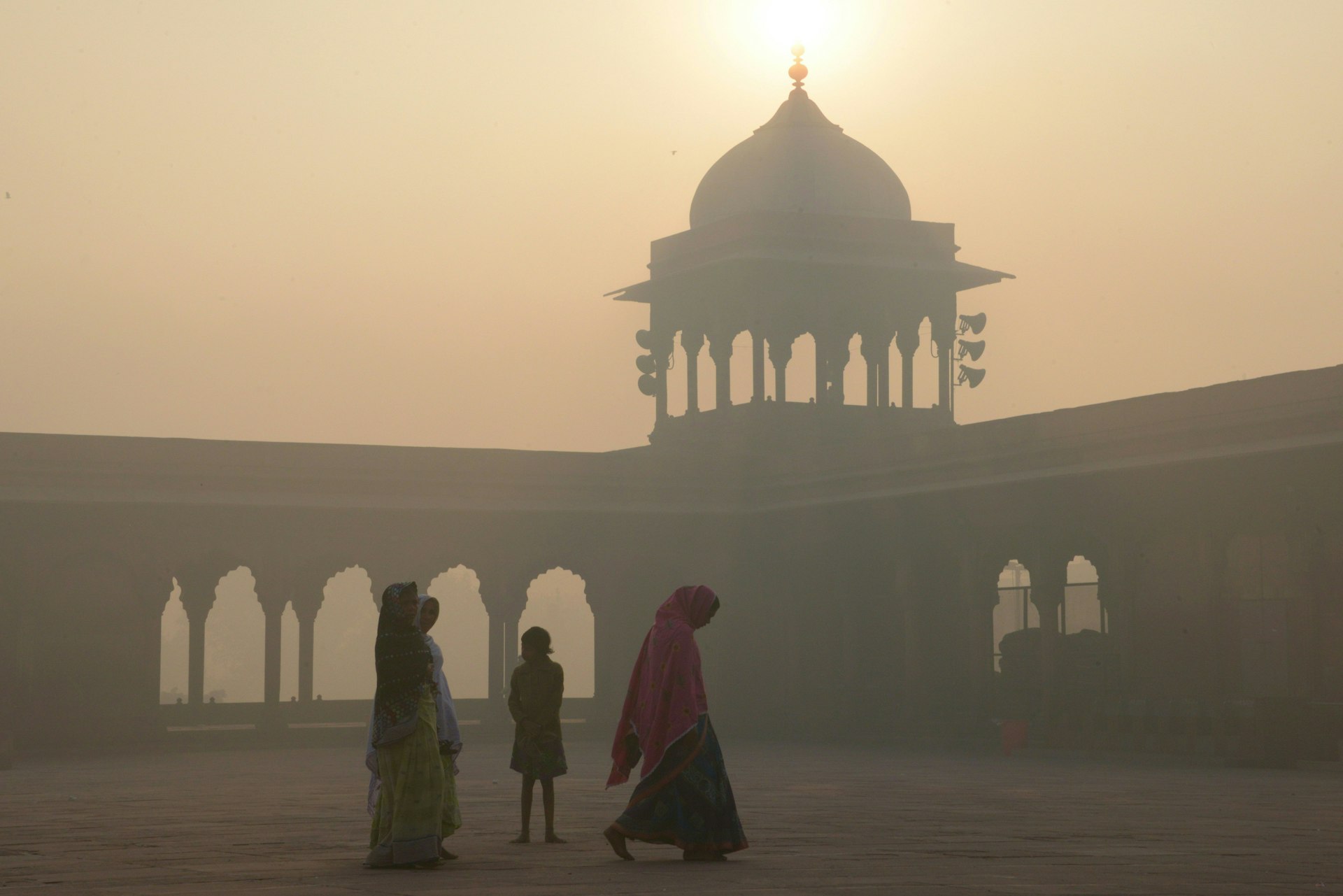 Women walk through the haze at Delhi's Jama Masjid mosque.