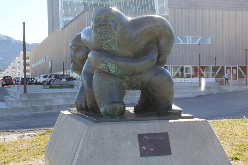 The sculpture titled 'Kaassassuk', positioned on a plinth in front of the parliament house, Nuuk.