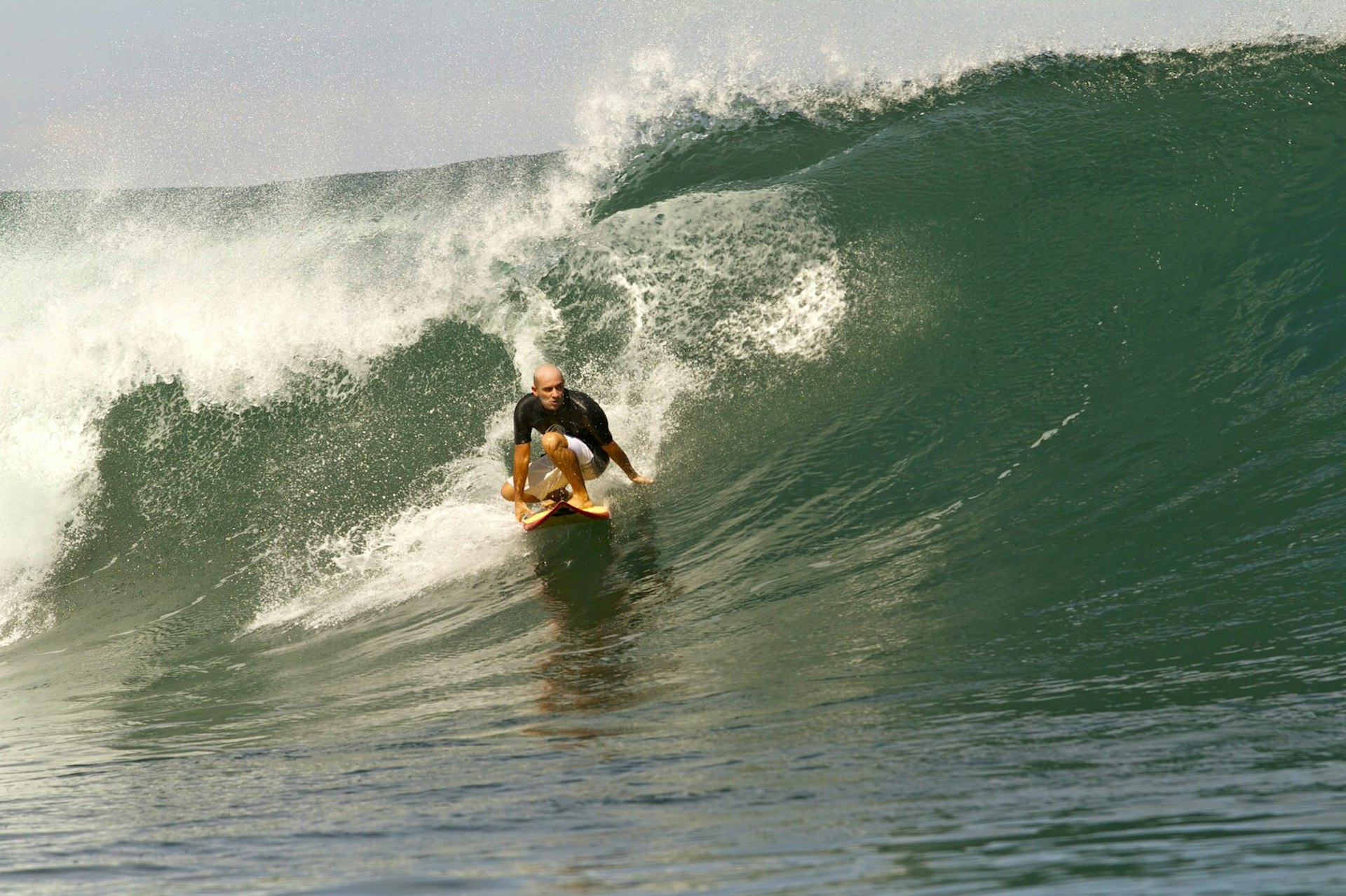 Lesser-known surfing spots - a surfer rides a large wave at Pico de Loro, Colombia