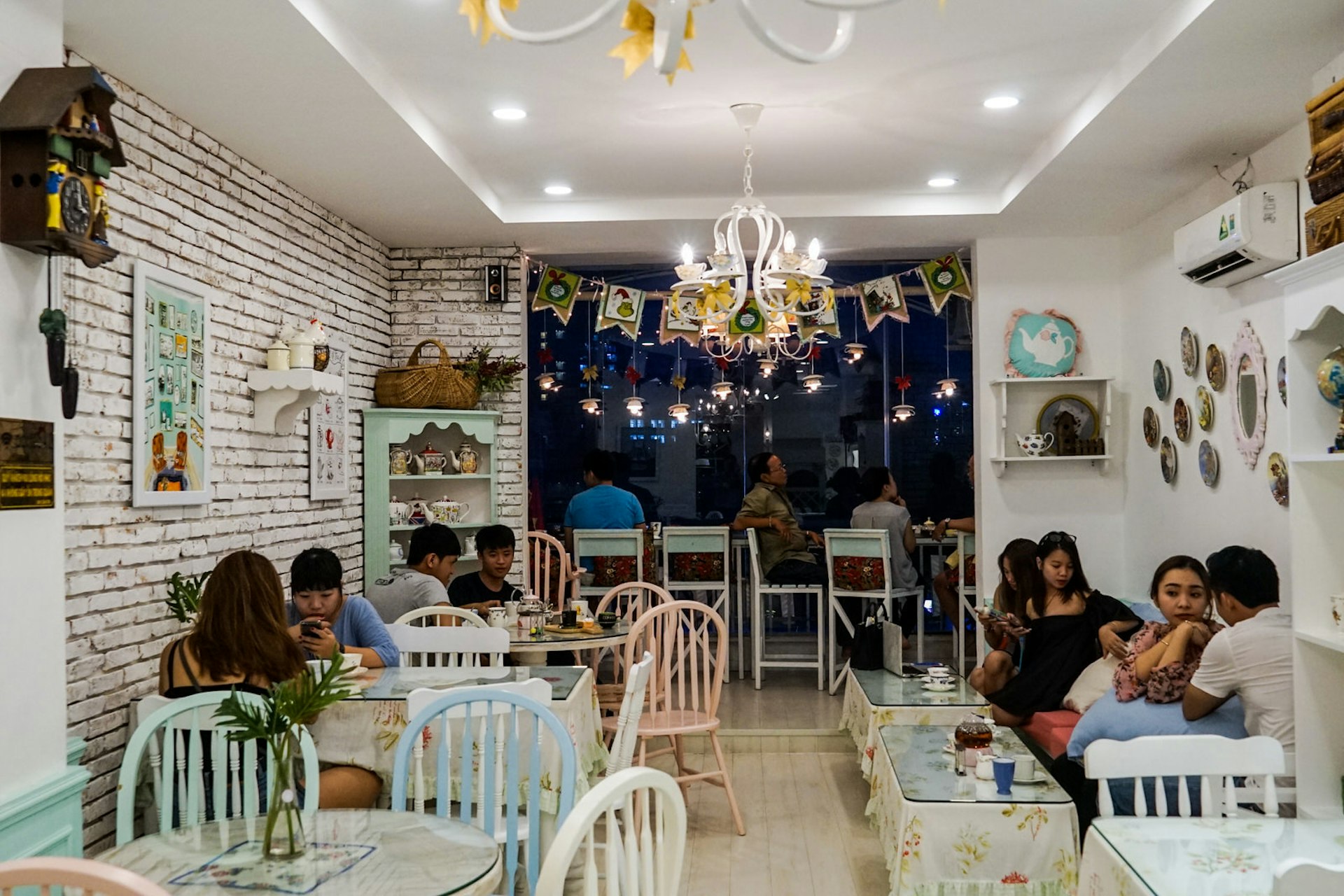 Customers socialise and drink tea at tables in Partea tearoom