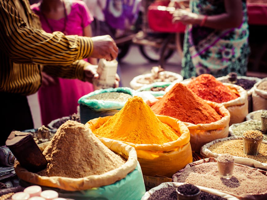 En försäljare packar ihop lite kryddor på en lokal basar i Indien