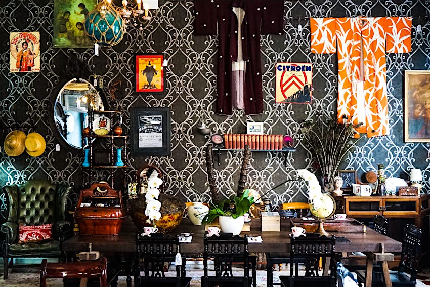 A table and wall at Villa Royale cafe, covered in a mix of items from around the world
