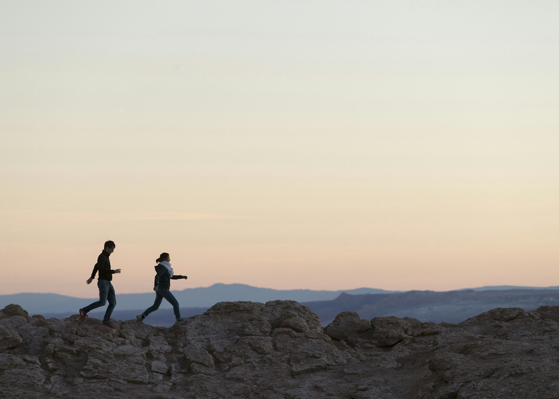 A couple walking along a ridge in the Atacama Desert, Chile © Philip Lee Harvey / Lonely Planet