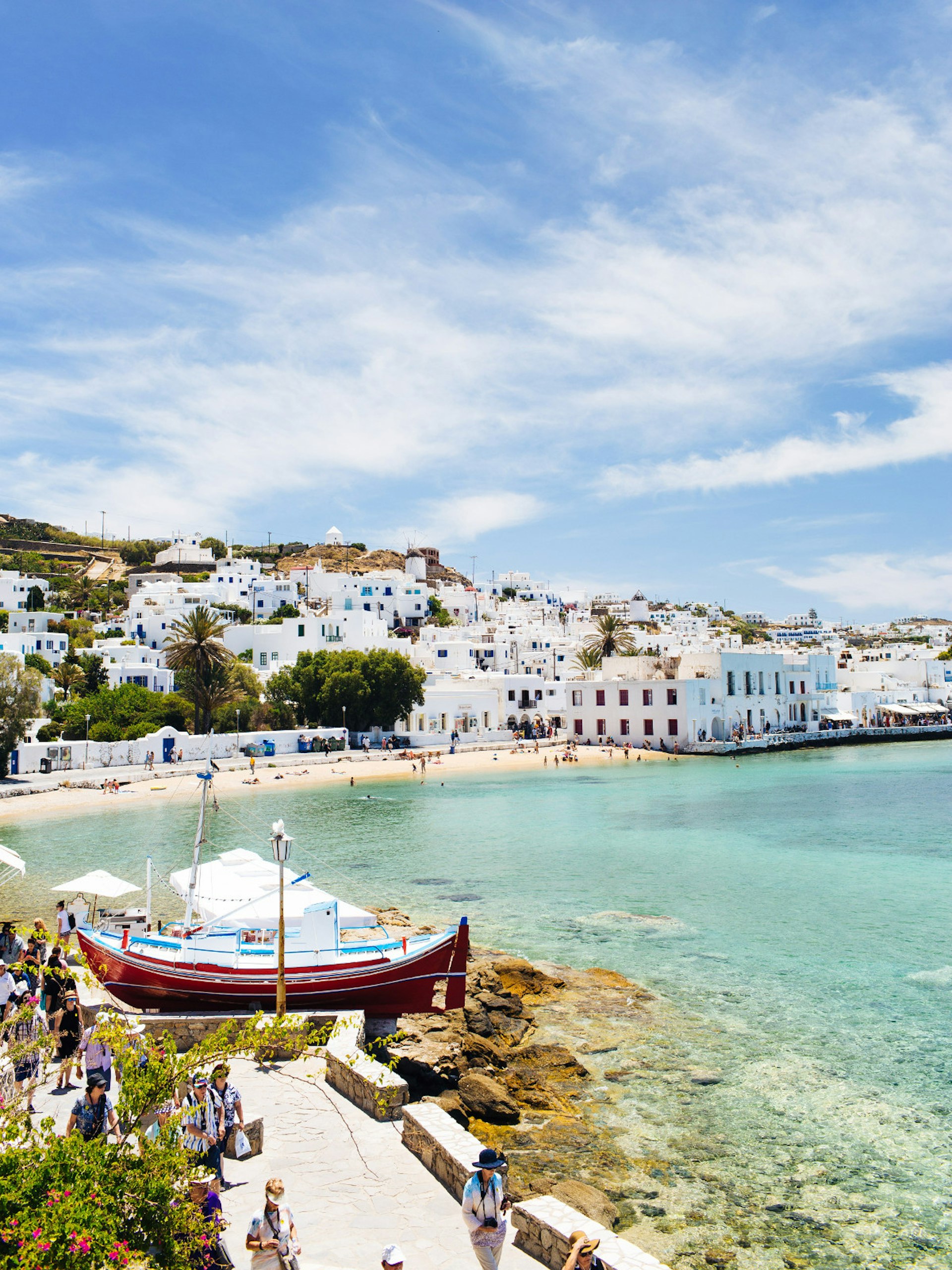 Visitors walking around Mykonos Harbor on a sunny day