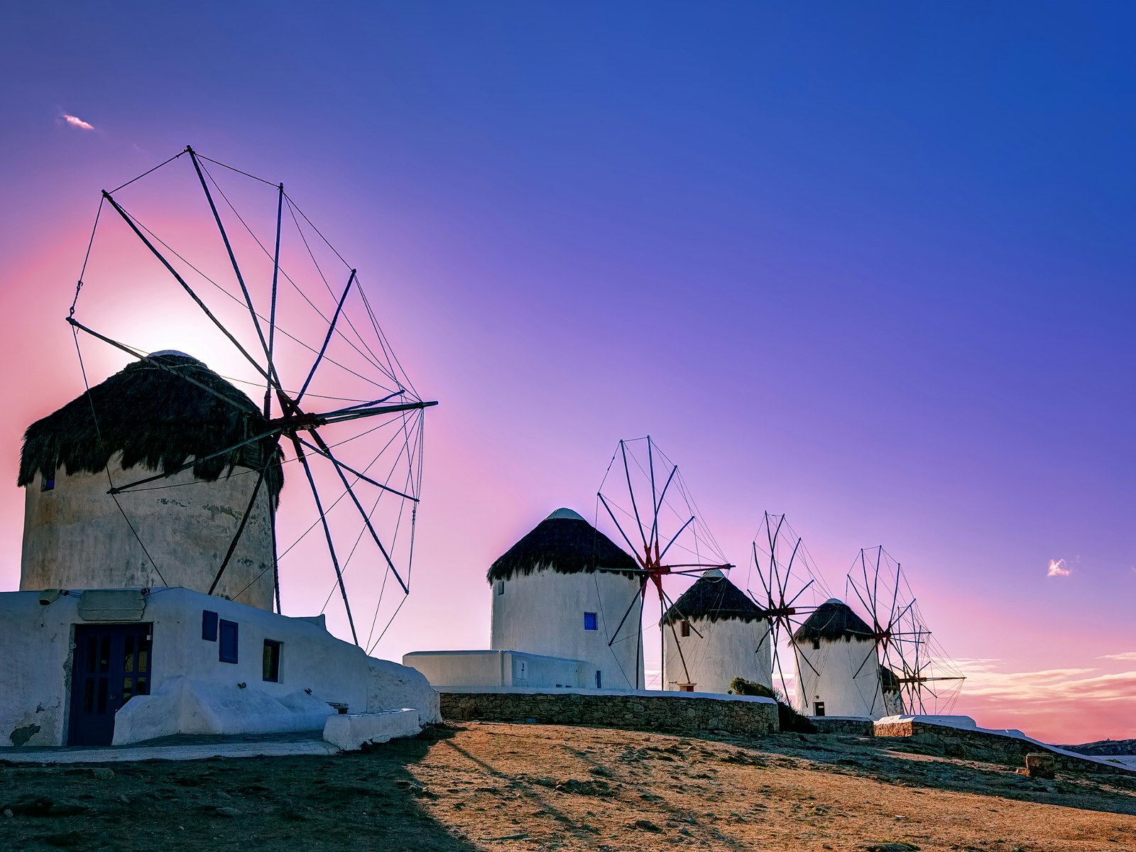 Four white, round windmills at sunset on Mykonos, Greece