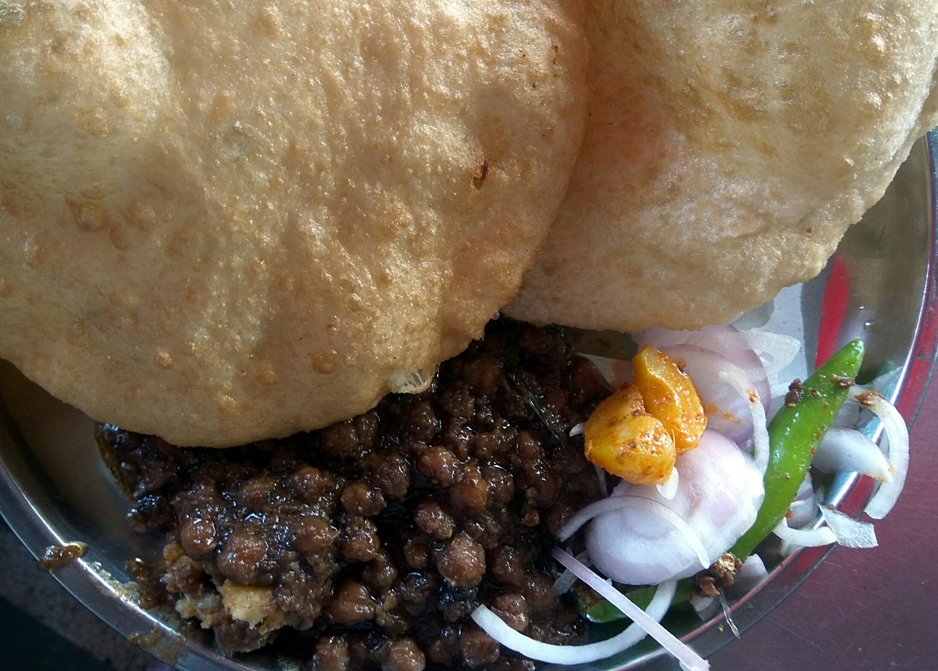 A plate of Chole bhatura – chickpea curry and fried bread stuffed with cottage cheese