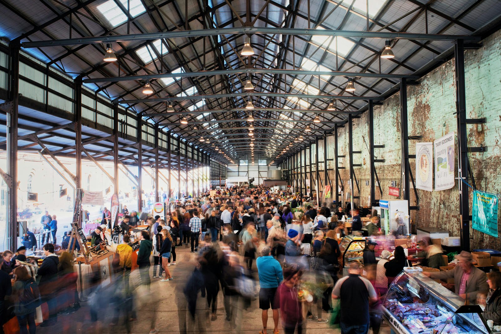 Crowds wander around the huge warehouse housing the Carriageworks Farmers Market