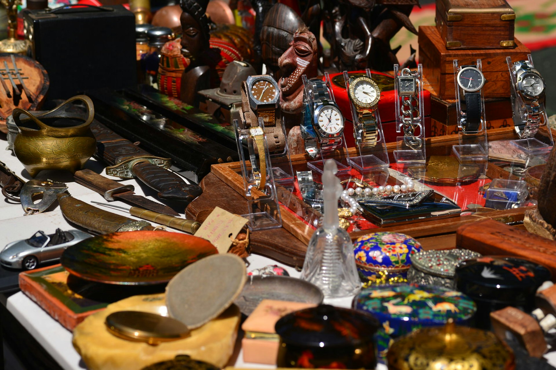 Various bric-a-brac is displayed at Rozelle Collectors Market including: watches, enamel boxes, knives, metal pots and wooden ornaments