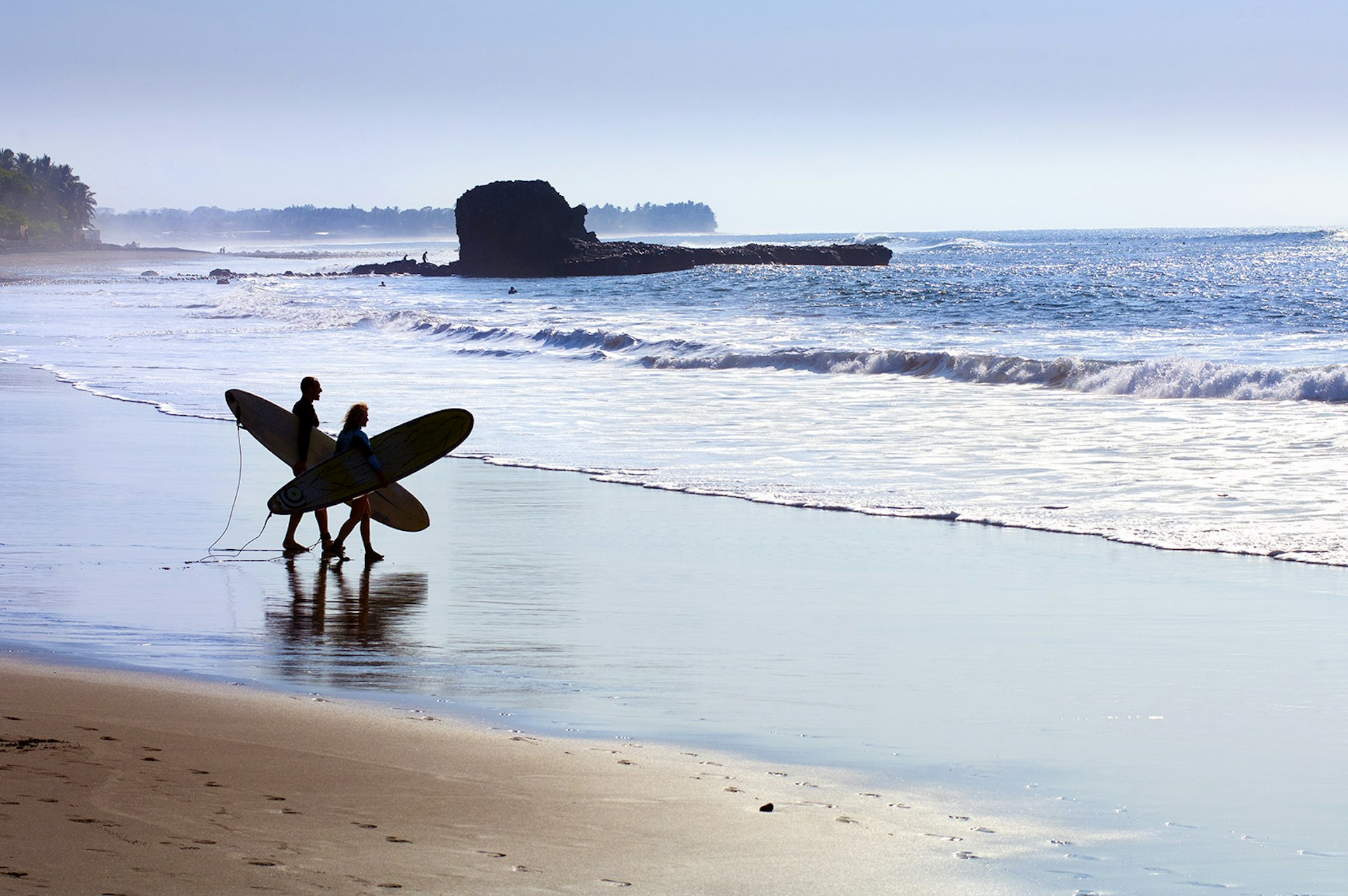 Features - El Salvador, Playa El Tunco, Surfers with boards at Pacific Ocean beach