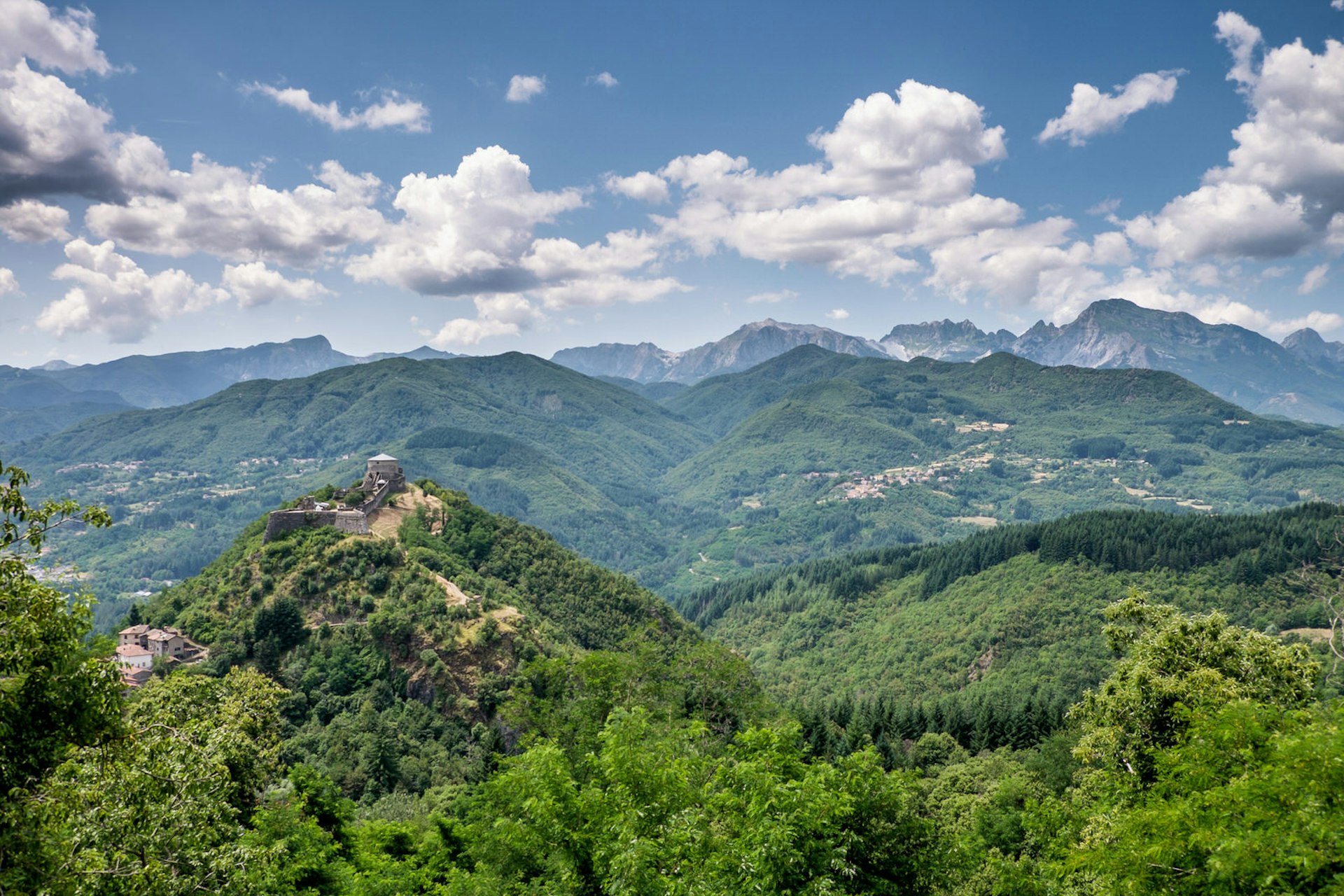 The rugged, forested hills of the Garfagnana, with mountains in the background © Getty Images