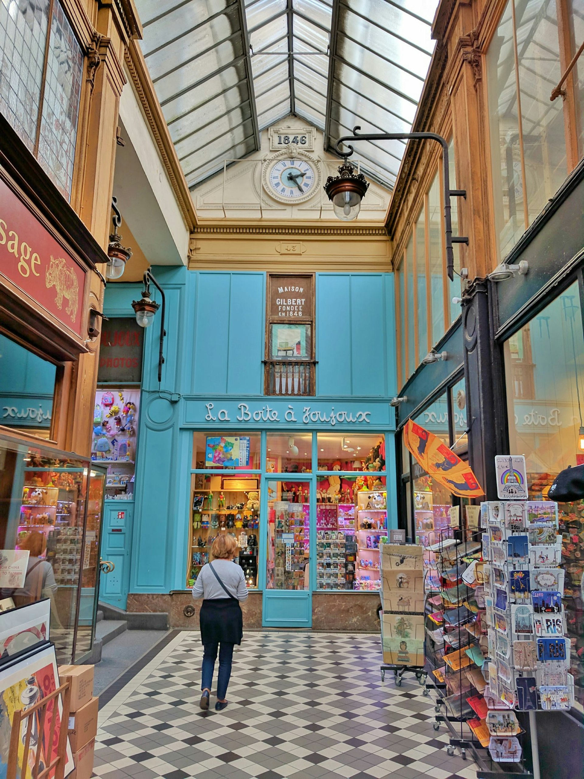 A woman walks towards a toy shop in the Passage Jouffroy, Paris