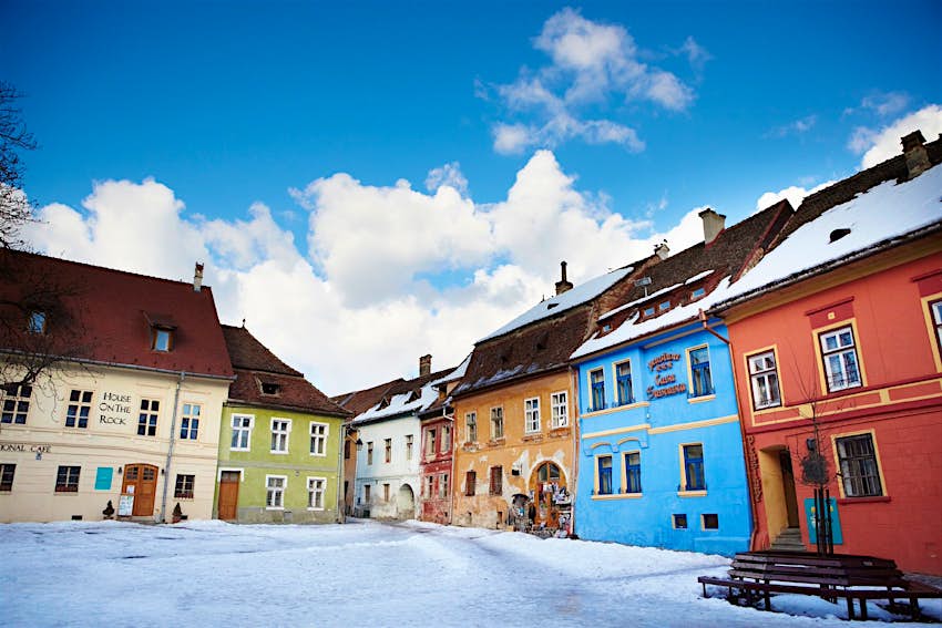Une place enneigée de maisons colorées à Sighişoara, Transylvanie.