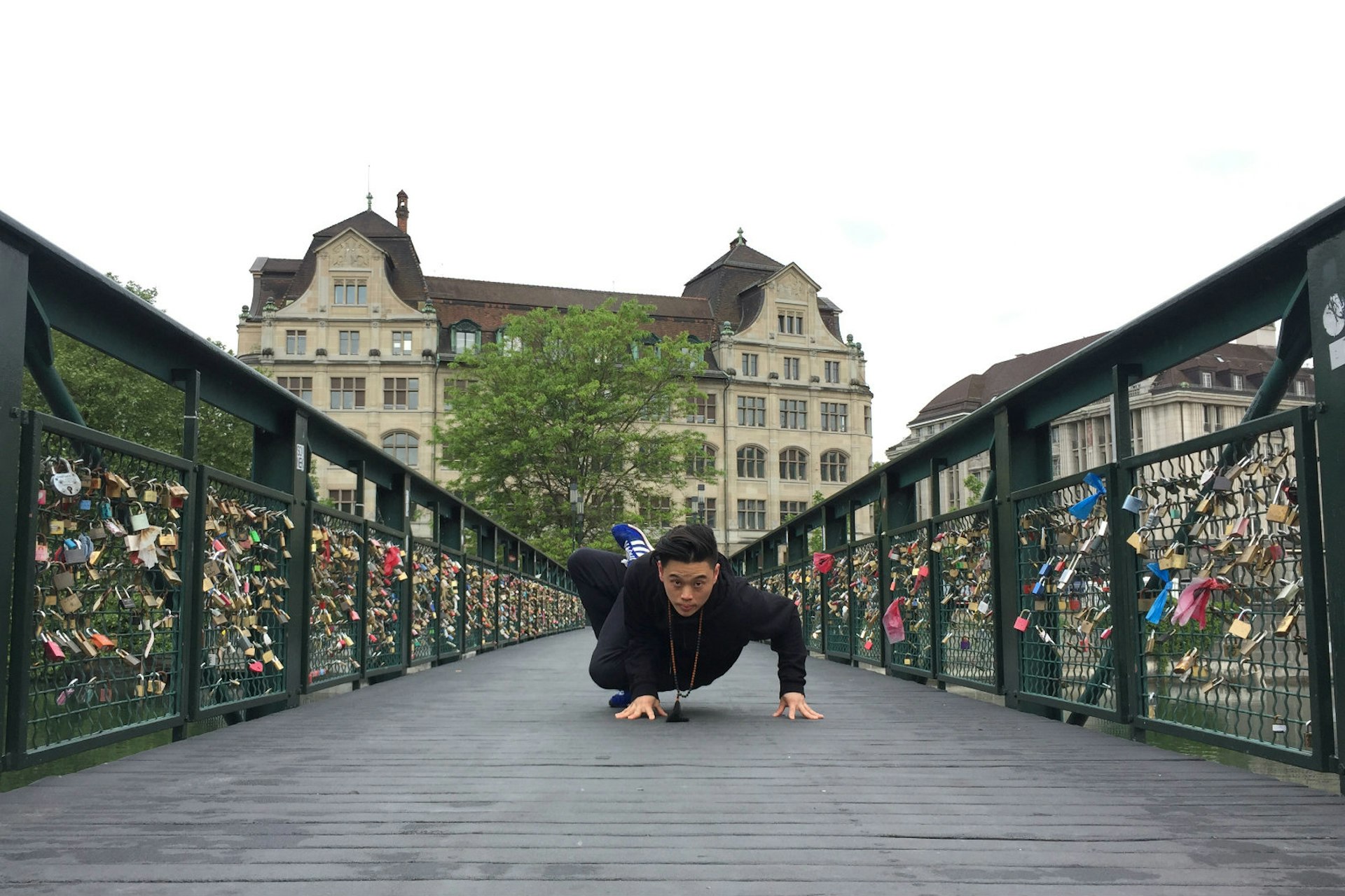 Michael James Wong does a yoga pose on a bridge in Switzerland