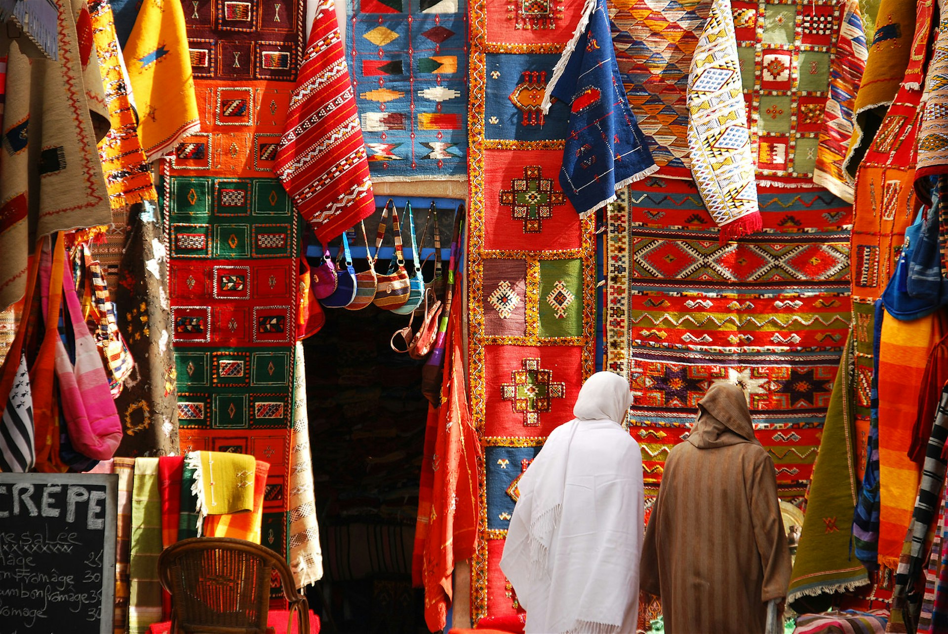 Women wandering through the Carpet Market in Essaouira, Morocco. Image by leuntje / Getty Images