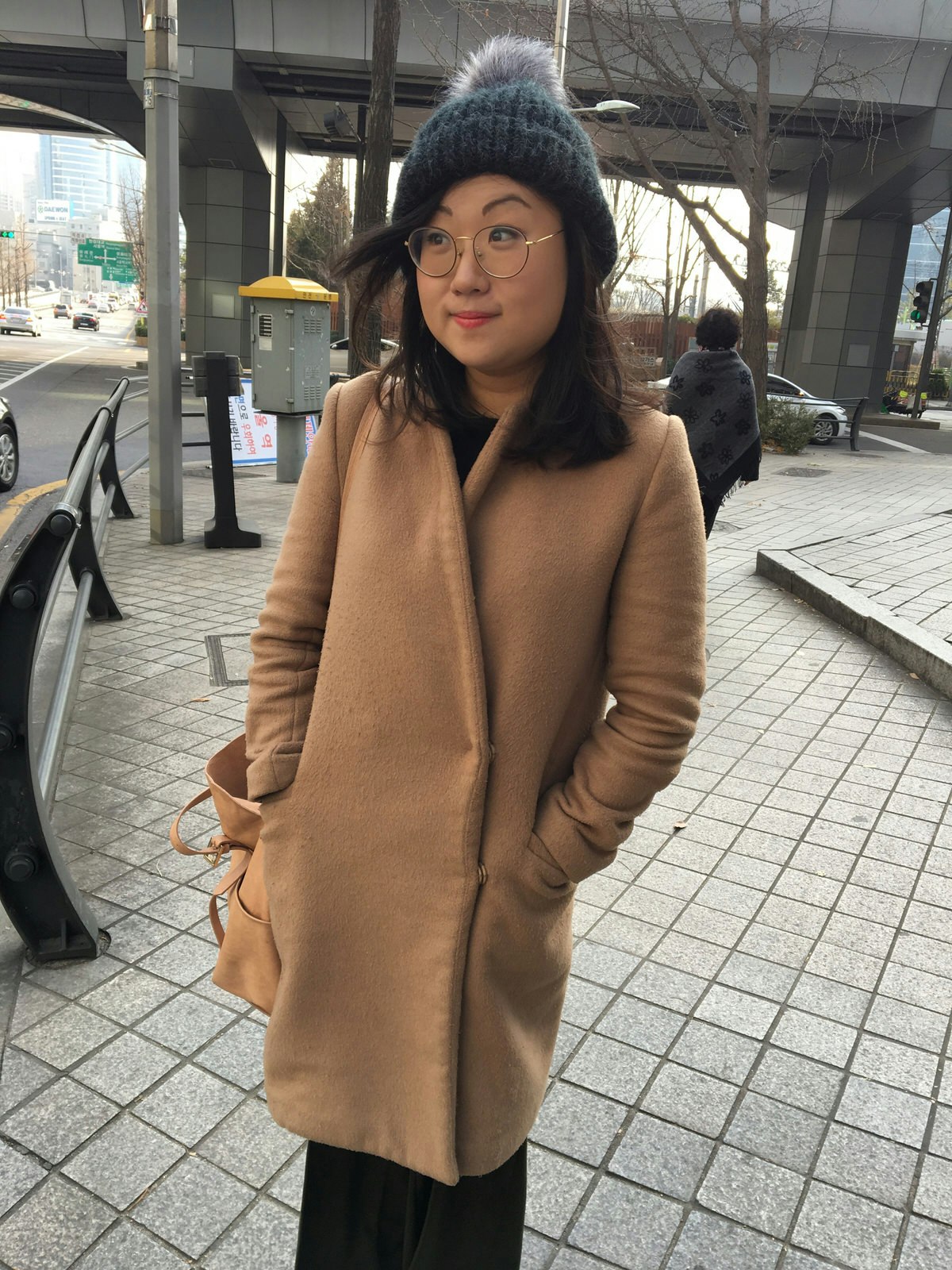 Hahna Yoon, Lonely Planet Local, wearing a beige overcoat and grey wool hat