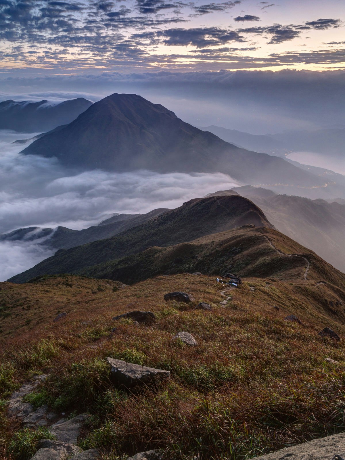 Clouds rolling over mountain on Lantau Island, viewed from the Lantau Peak (the second highest peak in Hong Kong, China) at dawn.