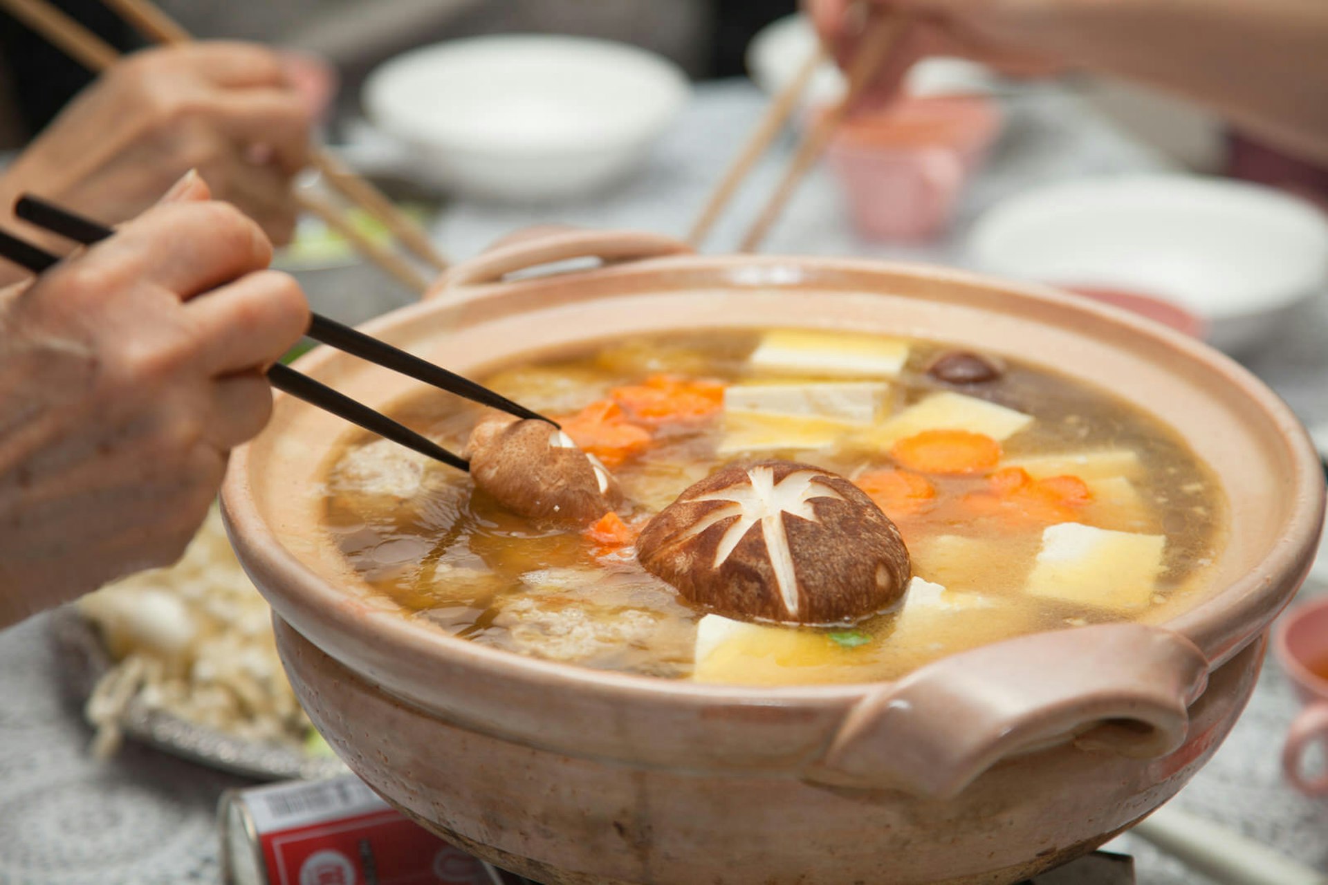 People share a nabe of broth and winter vegetables using chopsticks