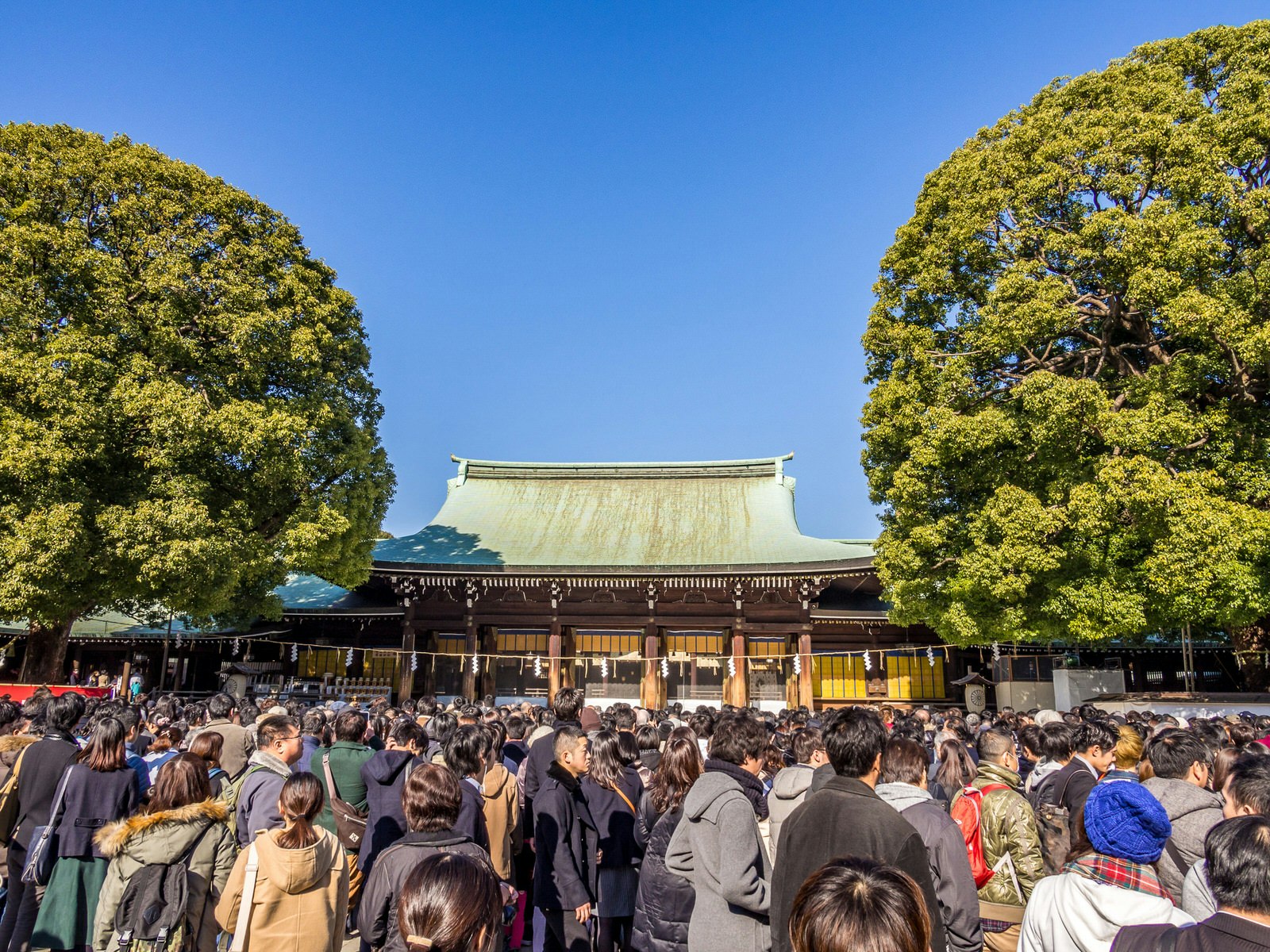 A large crowd gathered in front of the shrine Meiji-jingū in Tokyo on a clear winter day